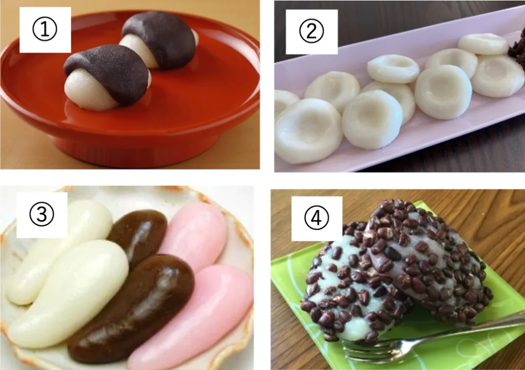 Two white mochi balls partially covered in black sesame glaze on a red plate.